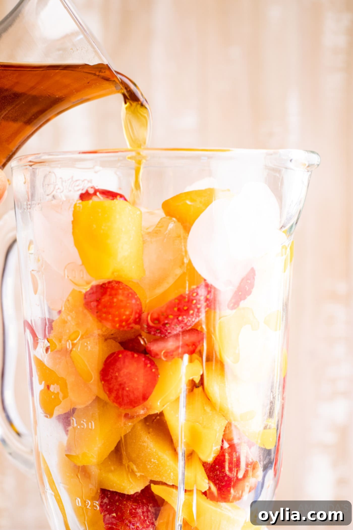Pouring rum into blender with fruit