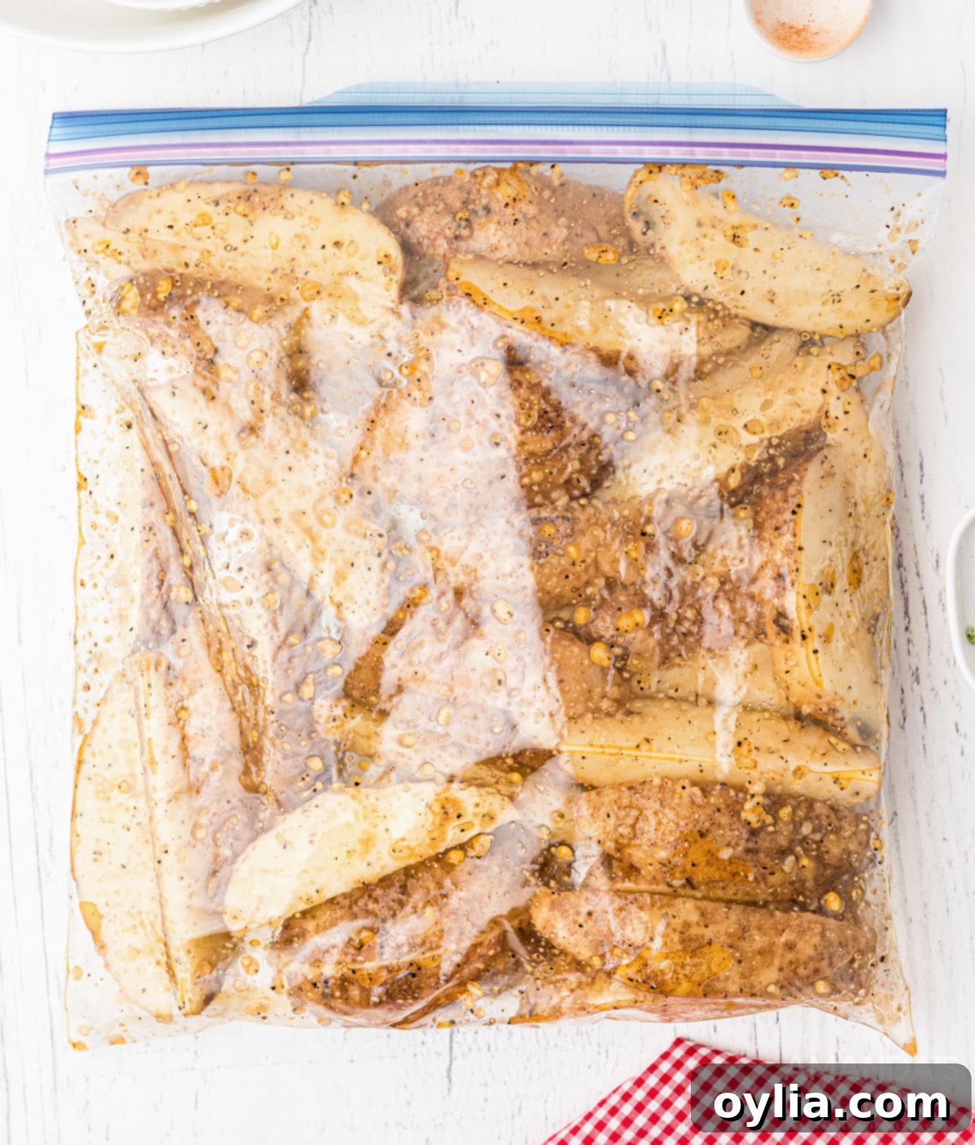 Potato wedges with seasoning in a Ziploc bag, ready for roasting