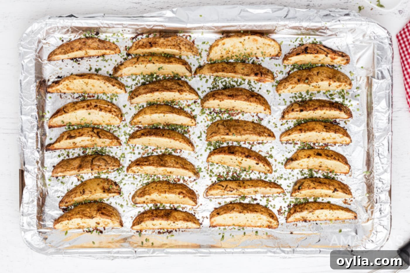 Roasted potato wedges on baking sheet, sprinkled with fresh chives