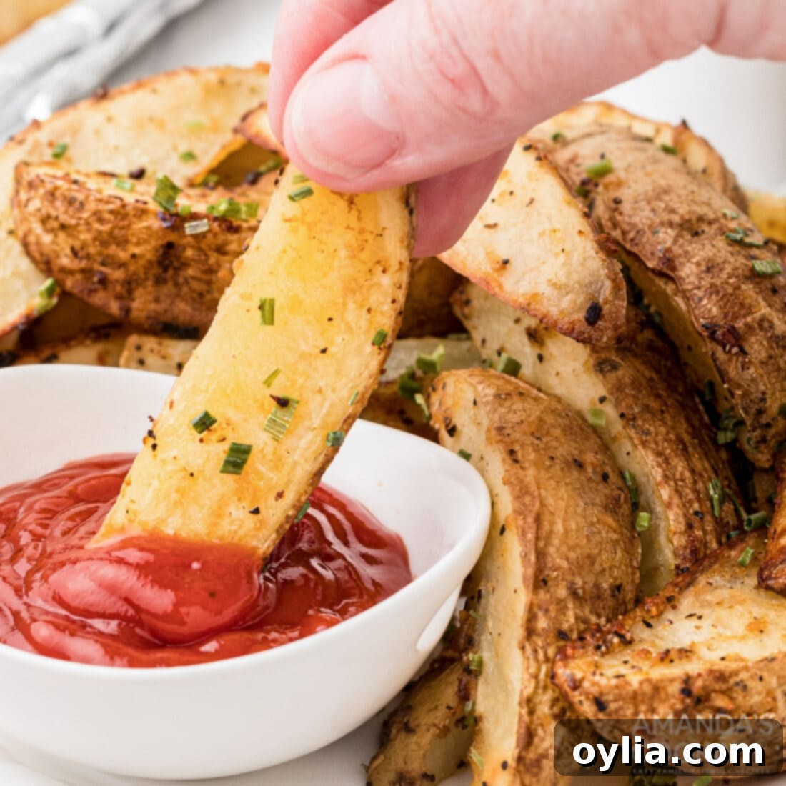 Dipping a roasted potato wedge in ketchup