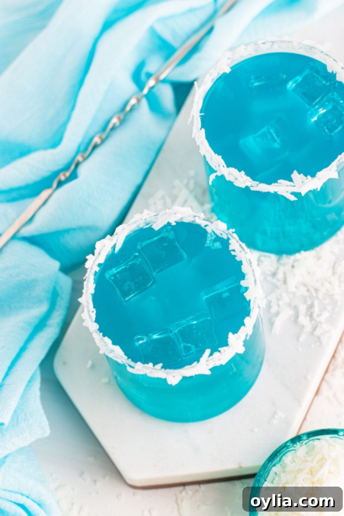 An overhead shot of two Ocean Water Cocktails, garnished with pineapple, evoking a perfect summer day.