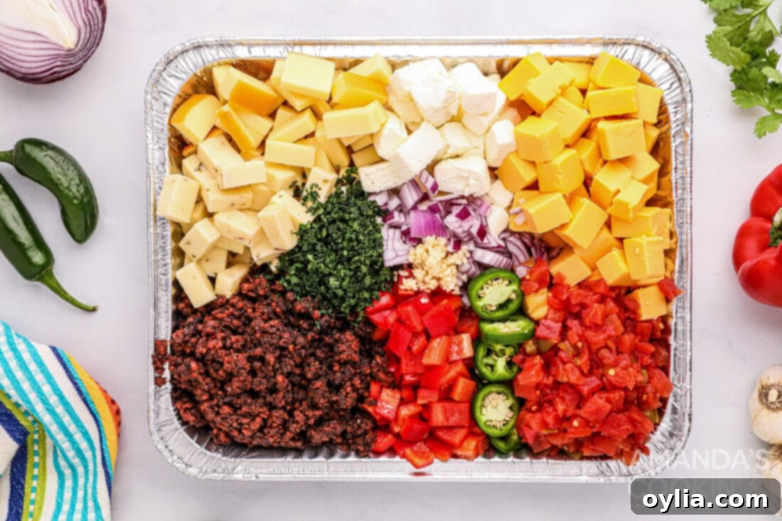 All ingredients for Smoked Queso Dip laid out in a 13x9 foil pan before smoking