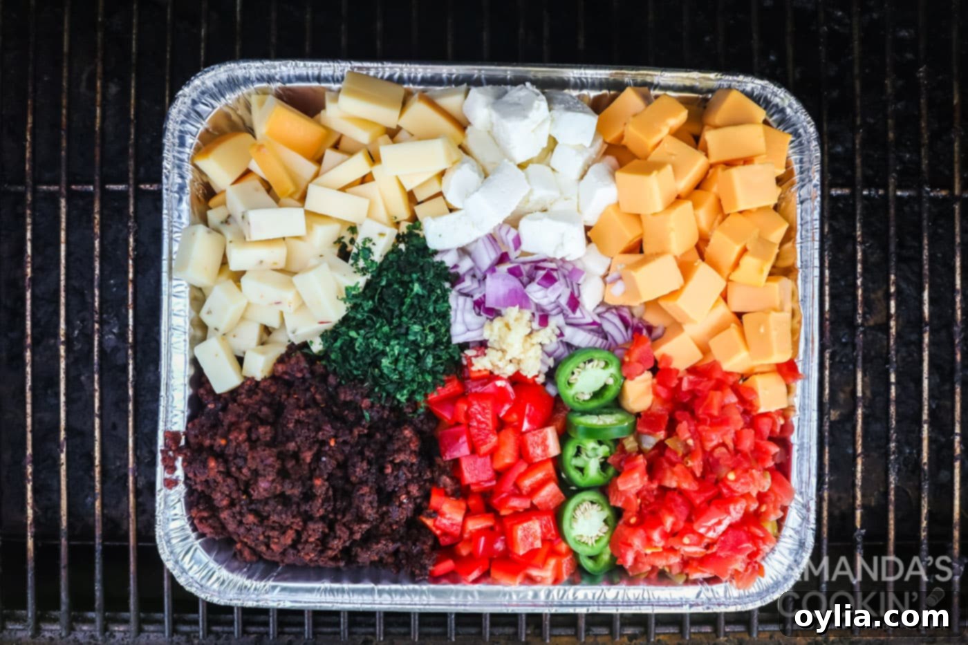 All Smoked Queso Dip ingredients prepped and layered in a 13x9 foil pan, ready for the smoker