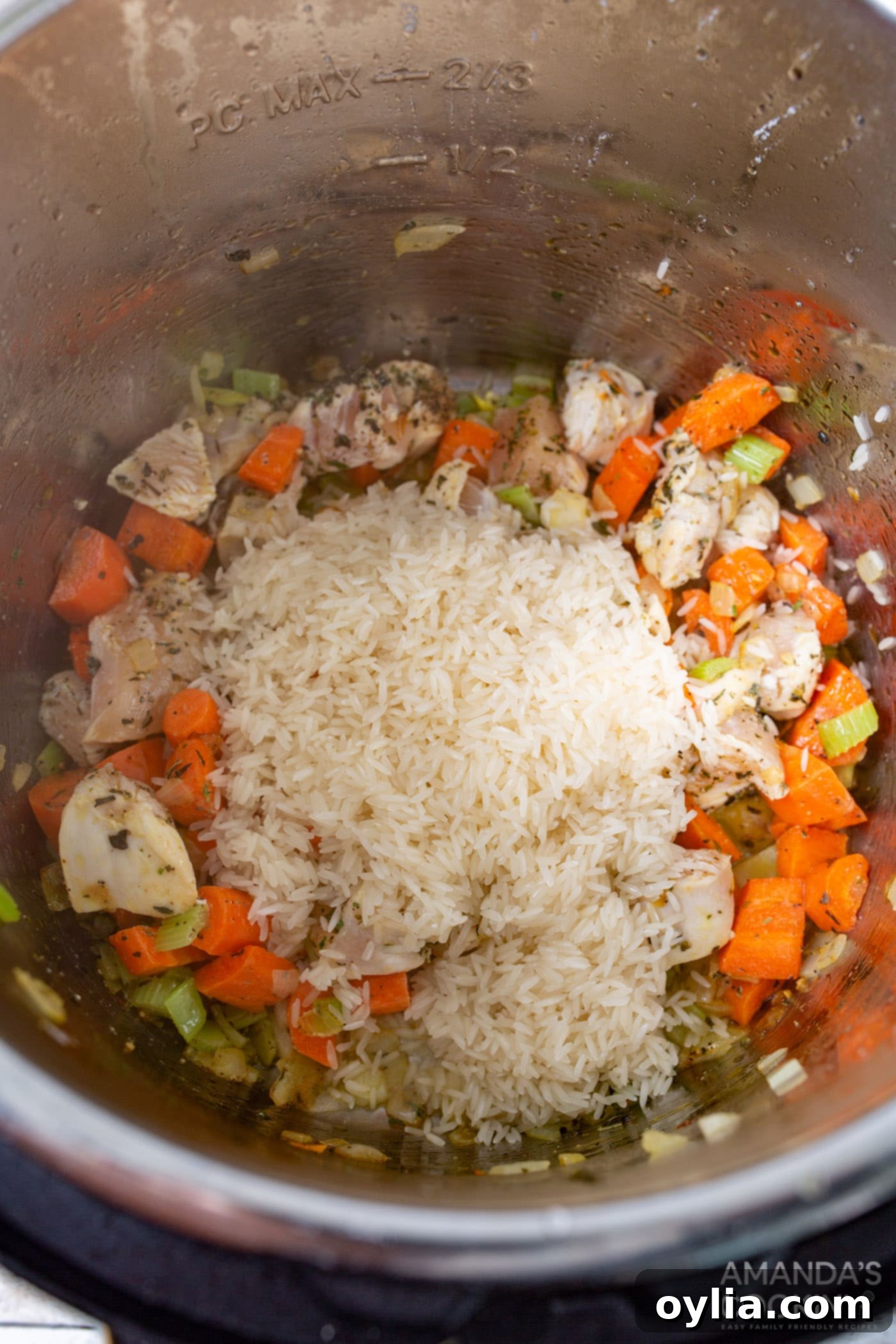 Rinsed white rice added to the Instant Pot with chicken and vegetables, gently stirred to combine.
