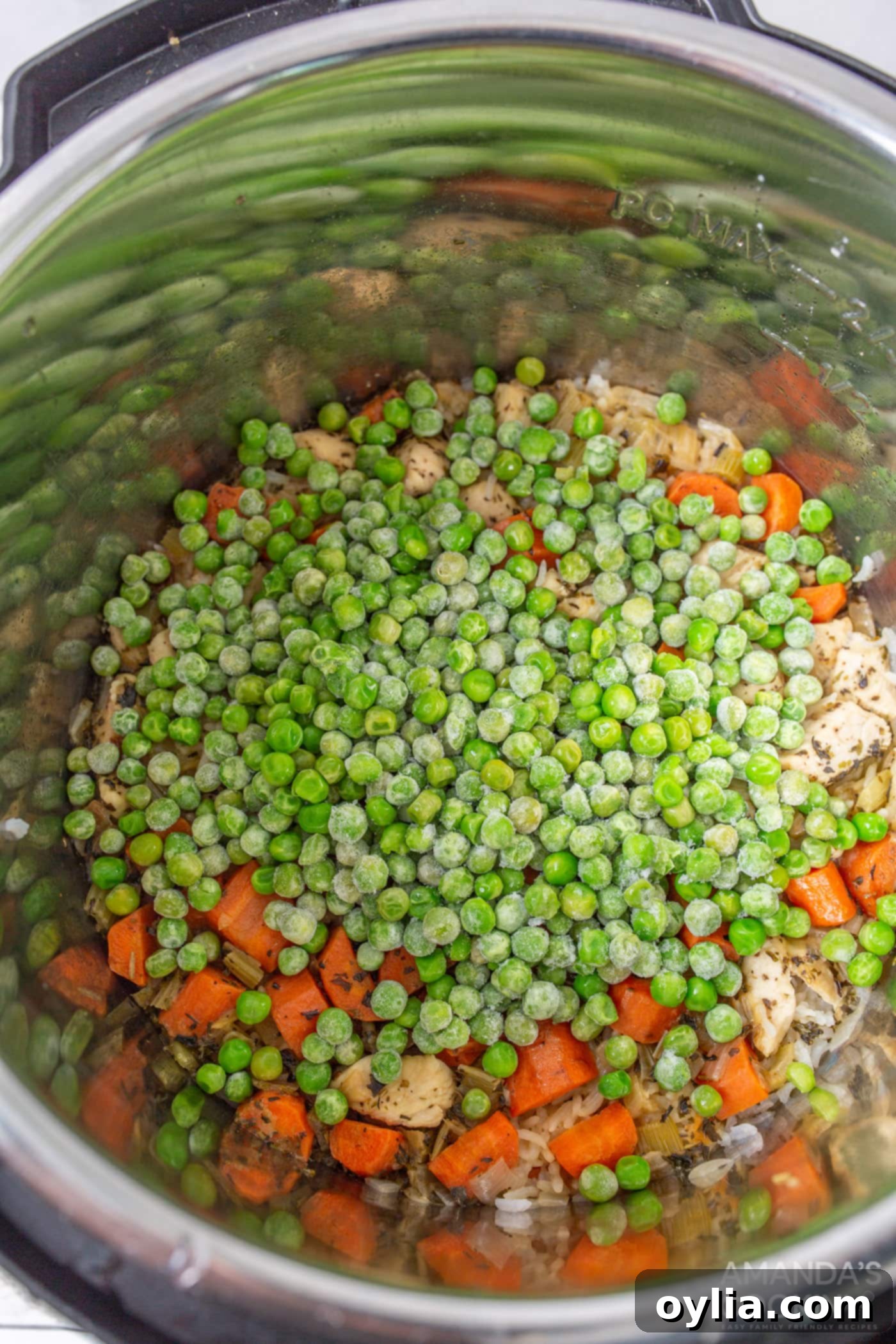 Frozen peas added to the freshly cooked Instant Pot chicken and rice, ready to be stirred in.
