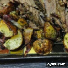 A close up photo of a serving of perfect Sunday roast on a plate with tender beef slices and roasted vegetables.