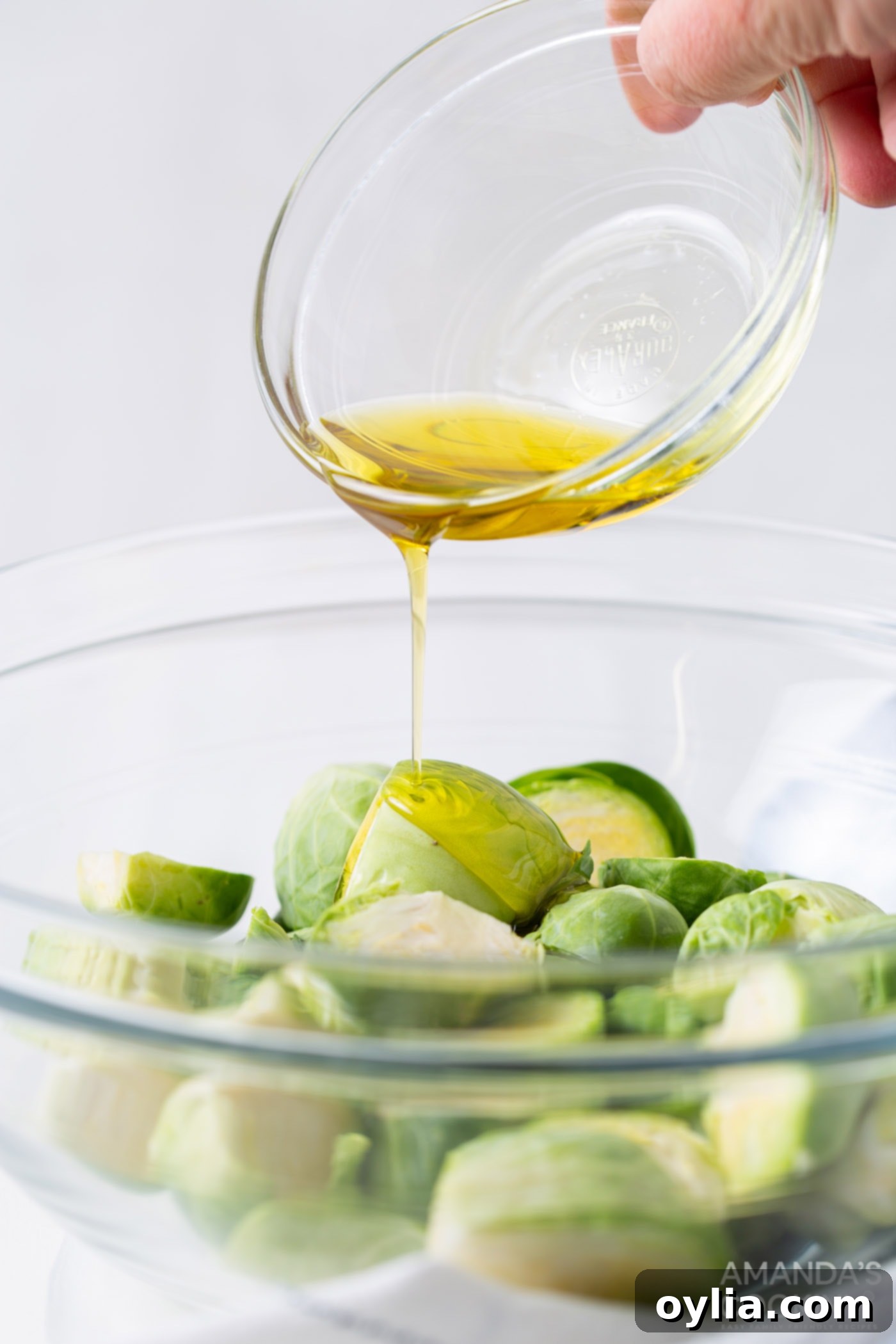 pouring olive oil onto brussels sprouts