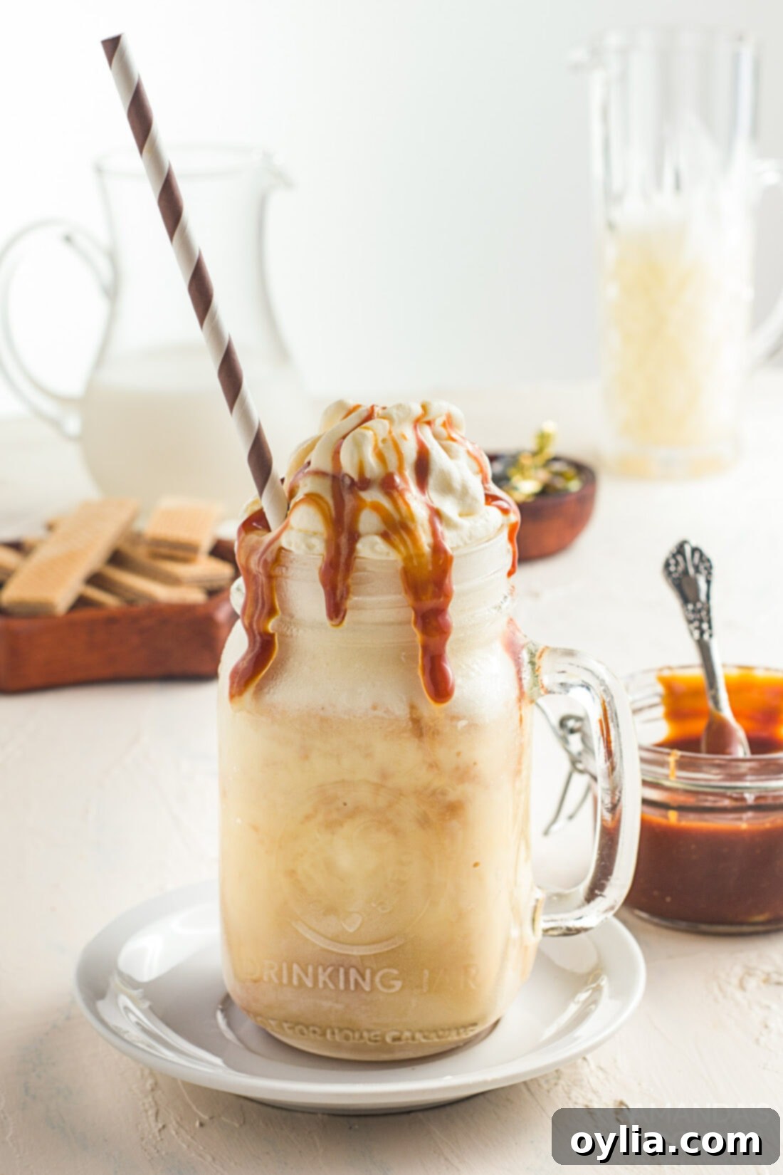 A decadent salted caramel milkshake overflowing with whipped cream and caramel drizzle, served in a classic mason jar glass.