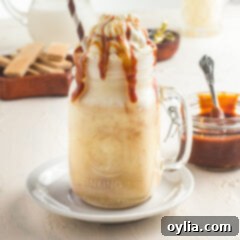 Delicious Salted Caramel Milkshake topped with whipped cream and caramel drizzle in a glass.