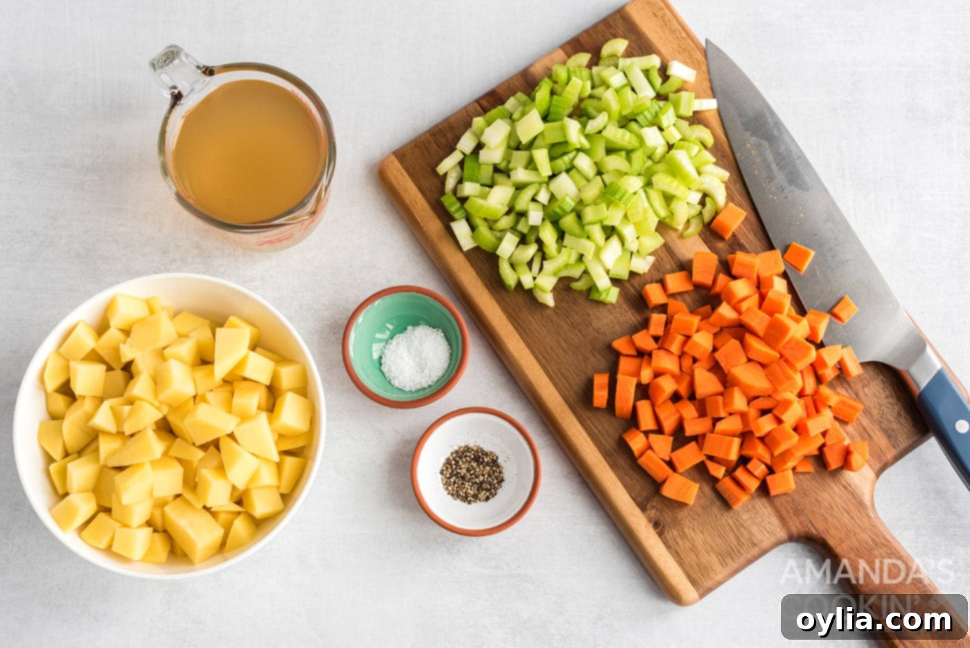 Freshly chopped potatoes, carrots, and celery on a cutting board, ready for the chowder.