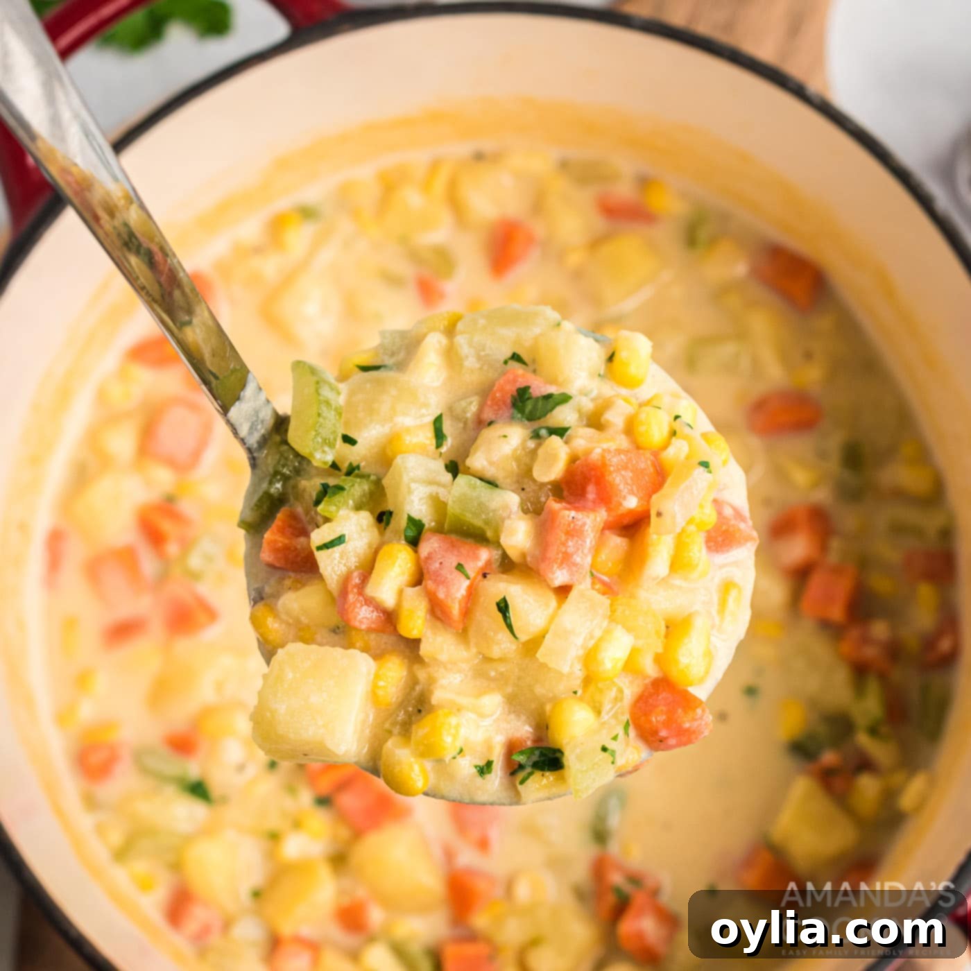 A ladle scooping creamy Corn Chowder from a pot, showing its rich texture.