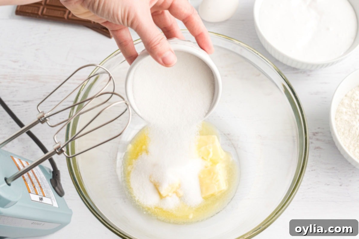 adding sugar to the bowl with butter