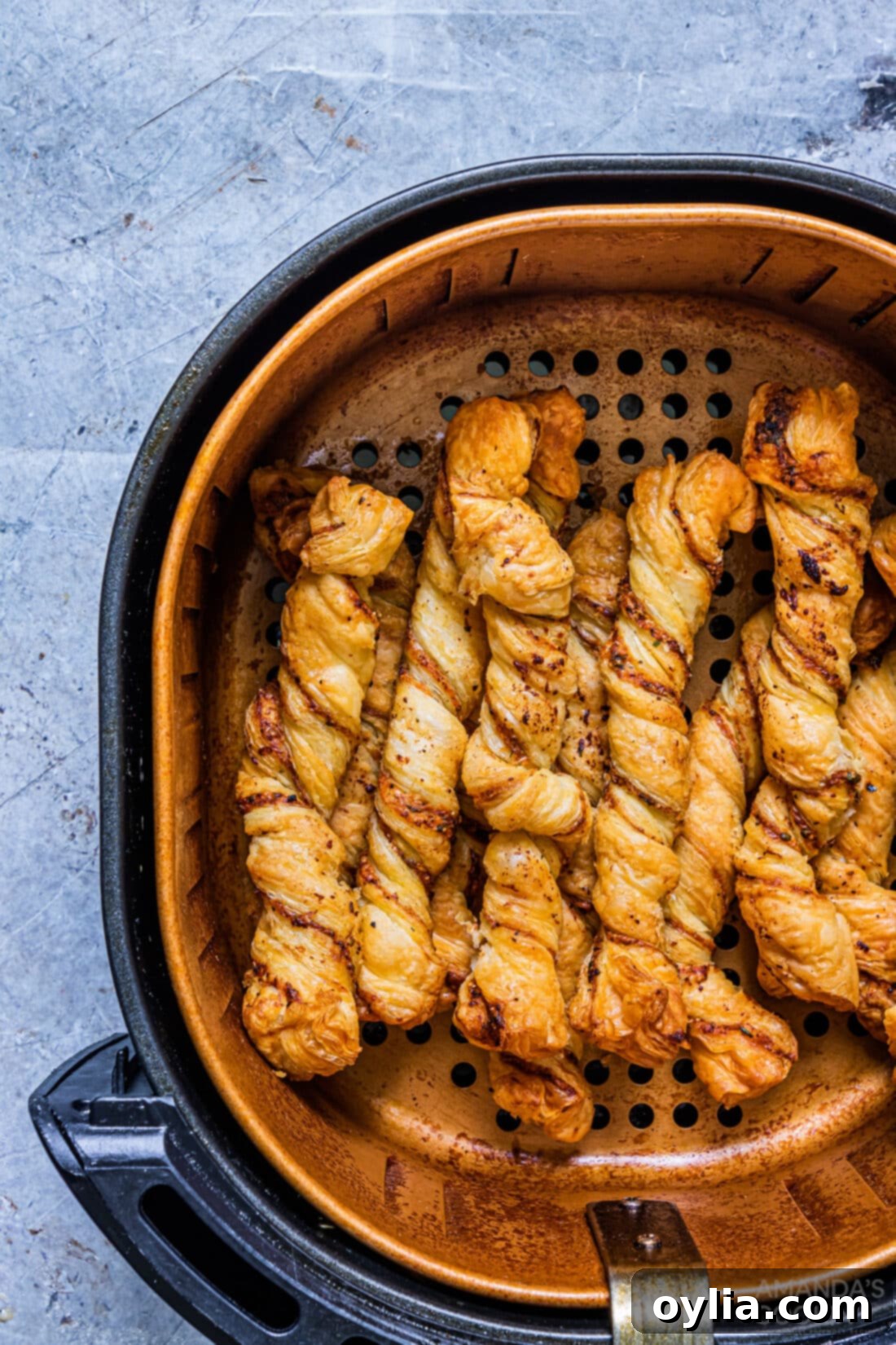 bread twists in air fryer basket, showing crispy texture