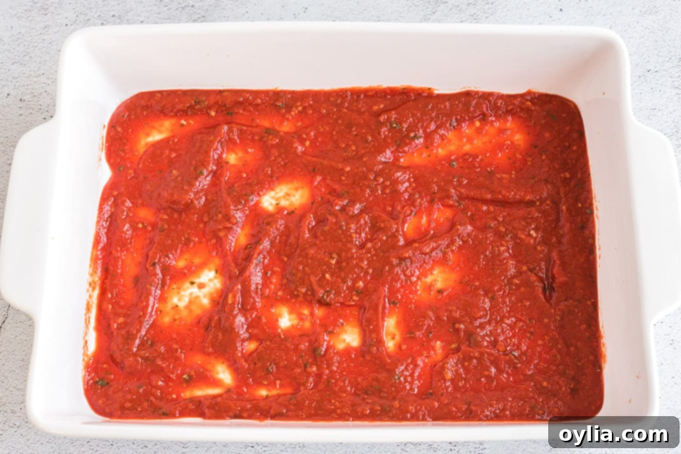 tomato sauce on bottom of baking dish