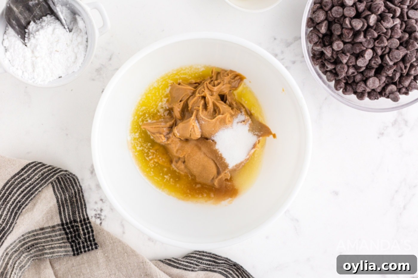 Mixing melted butter, creamy peanut butter, granulated sugar, and vanilla extract in a bowl for the base of chocolate peanut butter balls