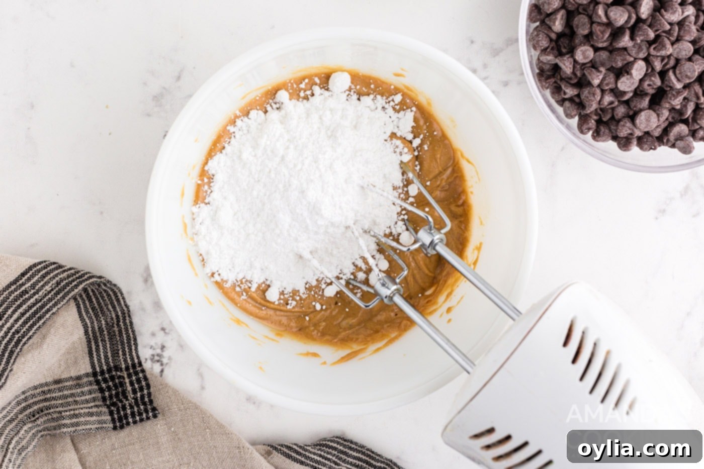 Adding powdered sugar to the peanut butter mixture and blending it to a crumbly consistency