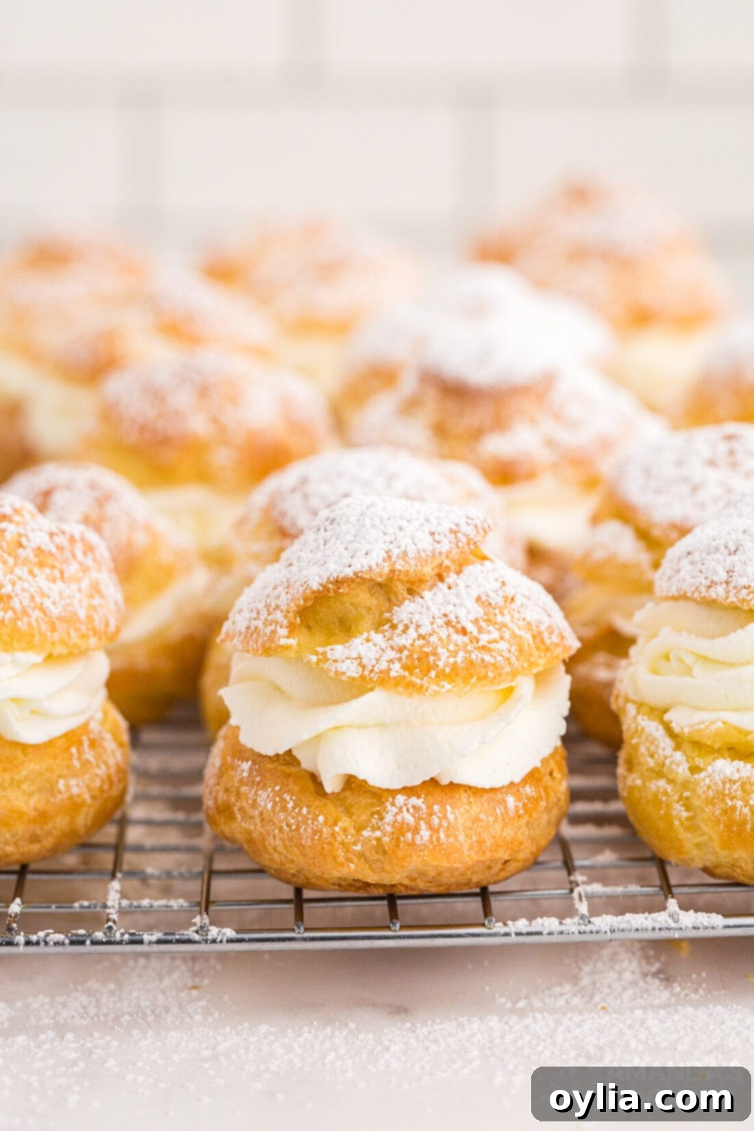 Freshly baked cream puffs cooling on a wire rack