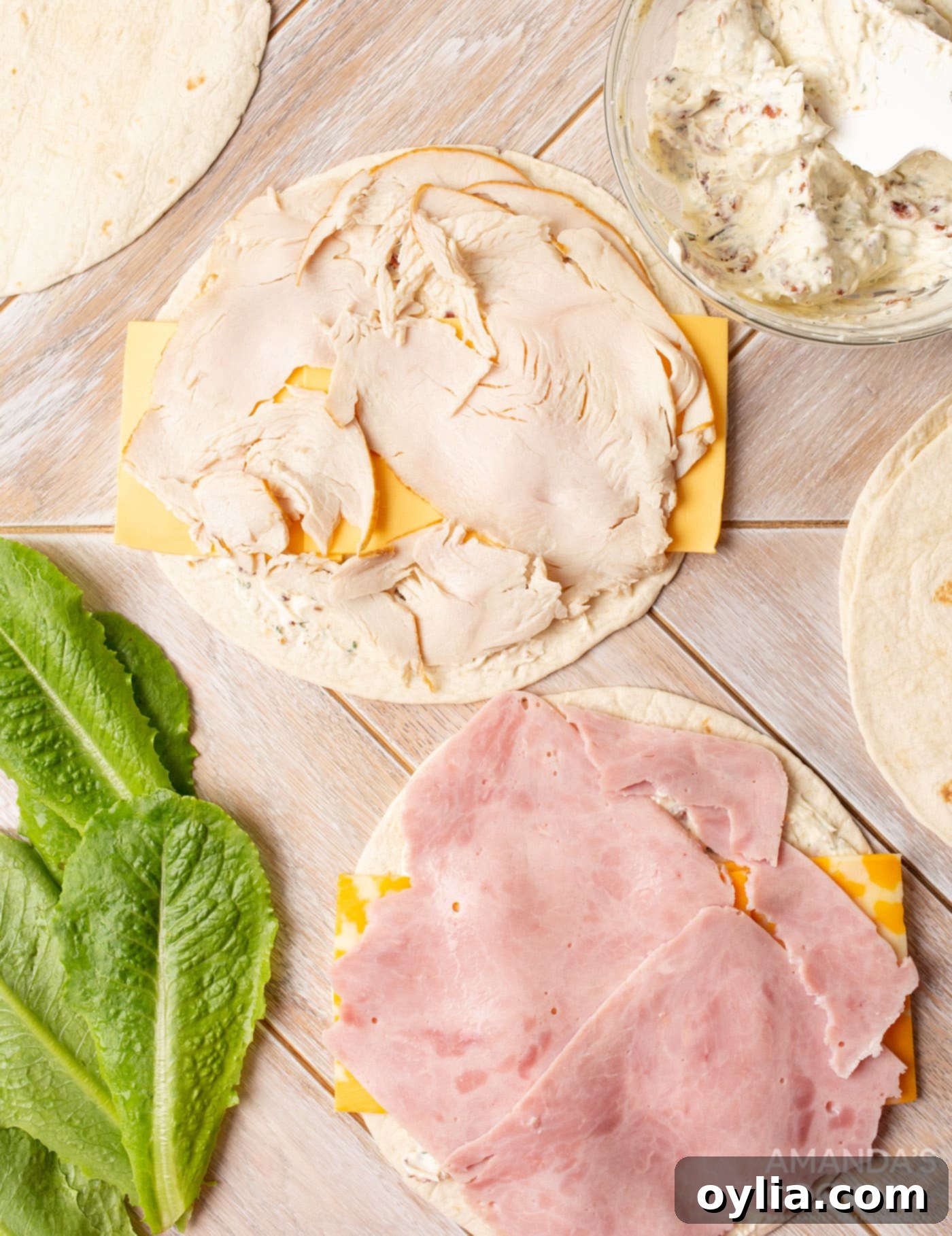 deli meat on top of tortilla with cream cheese and cheese slices