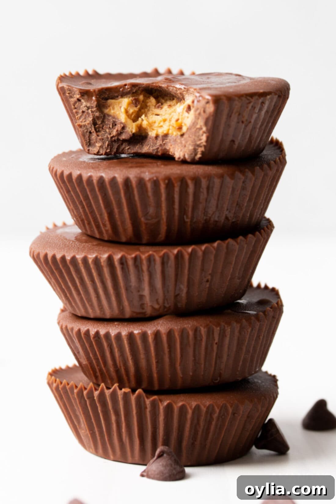 Stack of freshly made homemade peanut butter cups, showing their creamy filling and smooth chocolate shell.