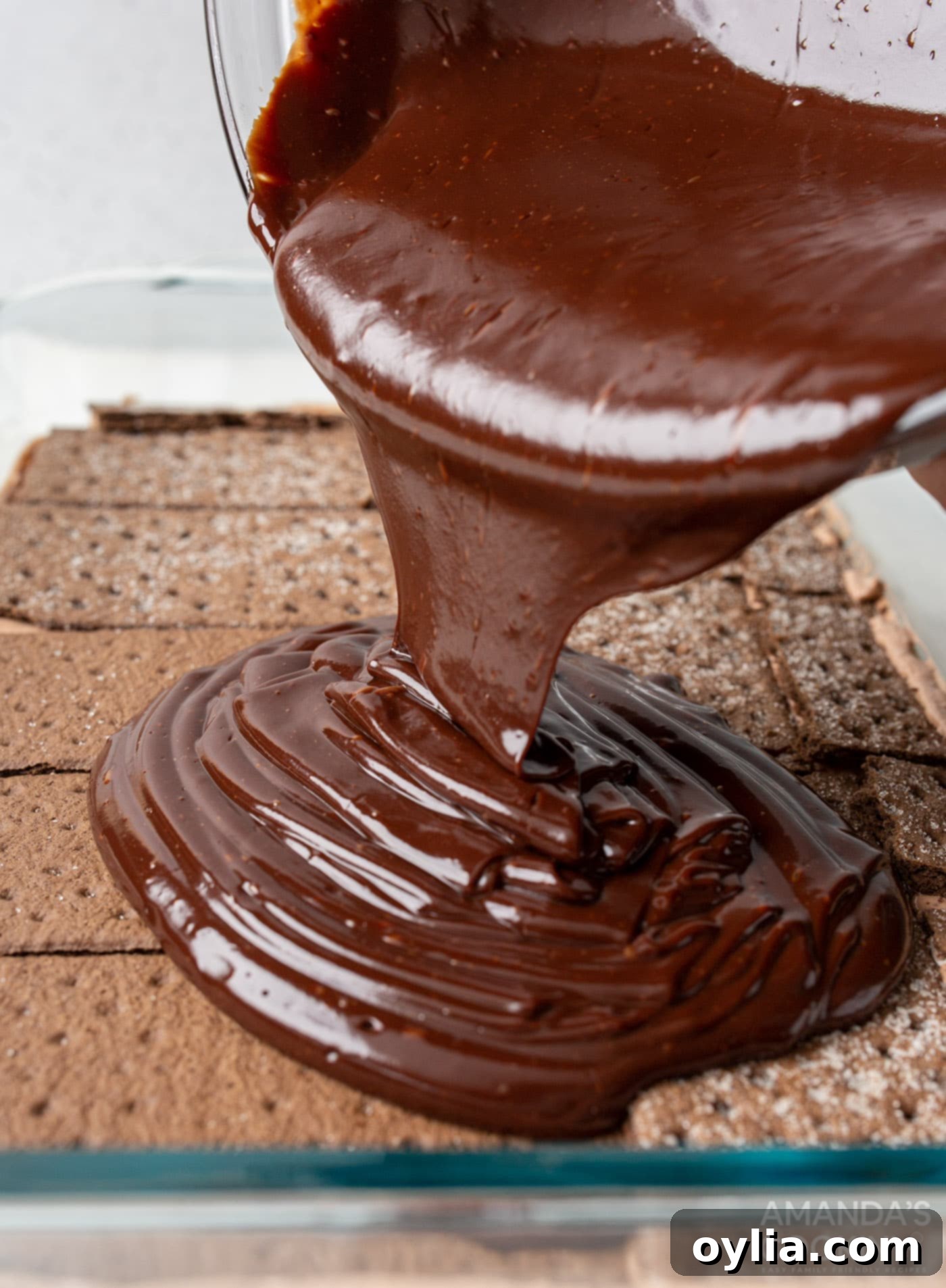 pouring ganache over chocolate graham crackers