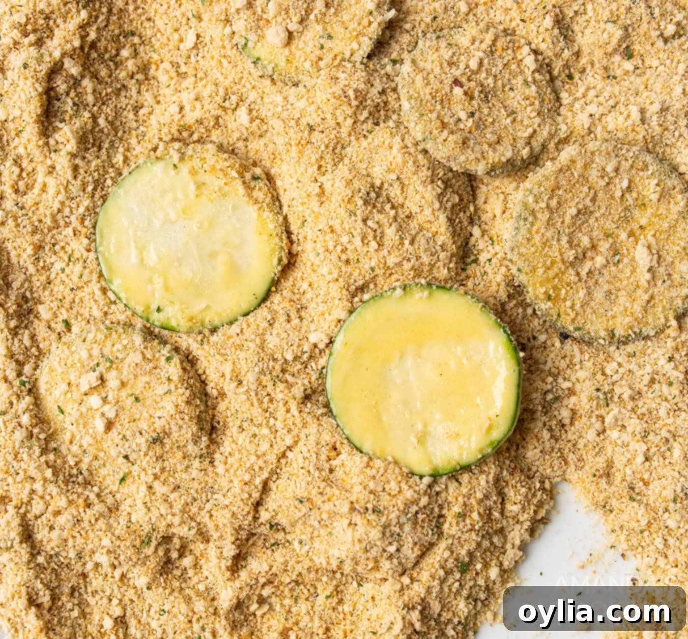 dipping zucchini slices in breadcrumbs and parmesan cheese mixture