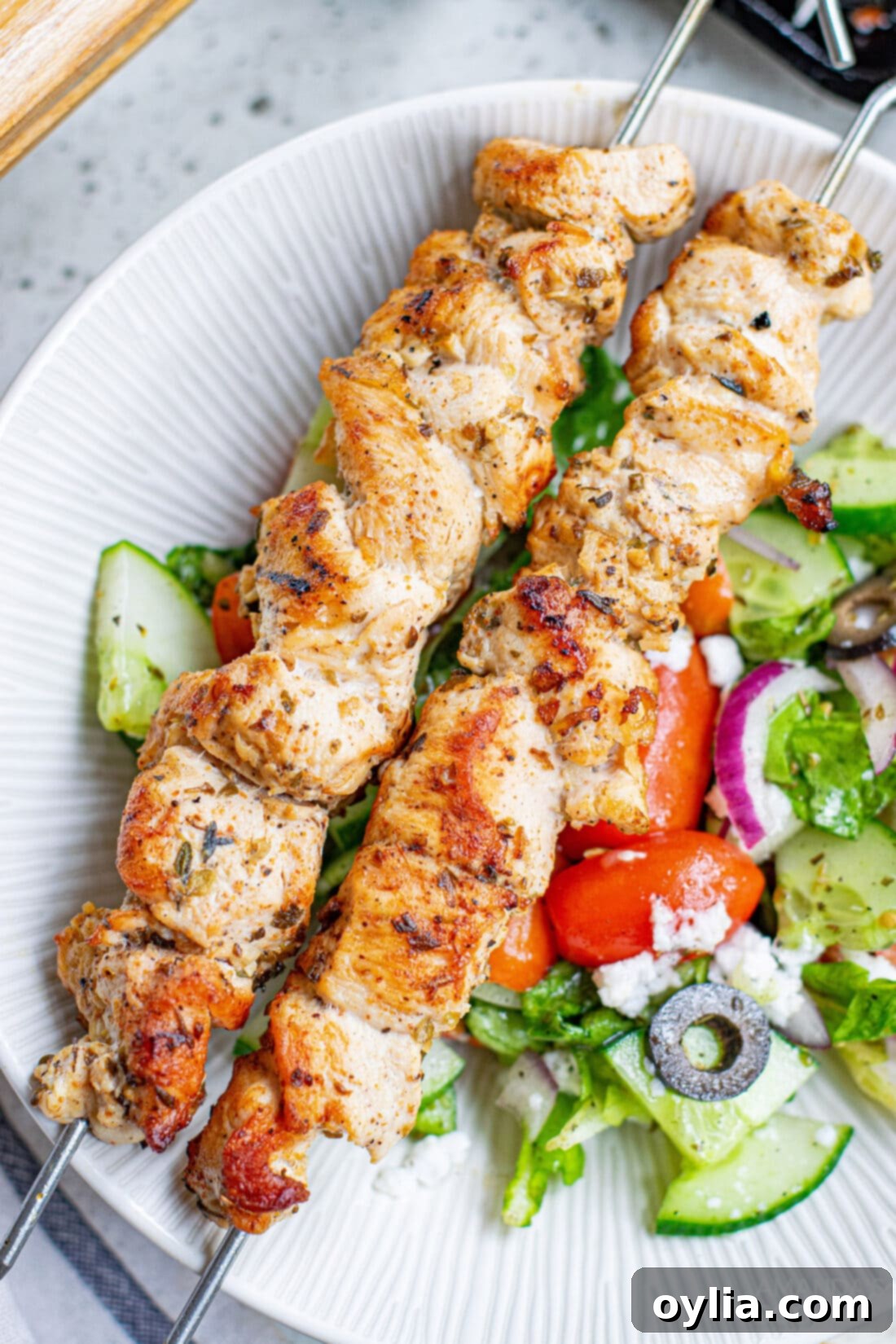 Plated Greek Chicken Kabobs with fresh salad and Tzatziki