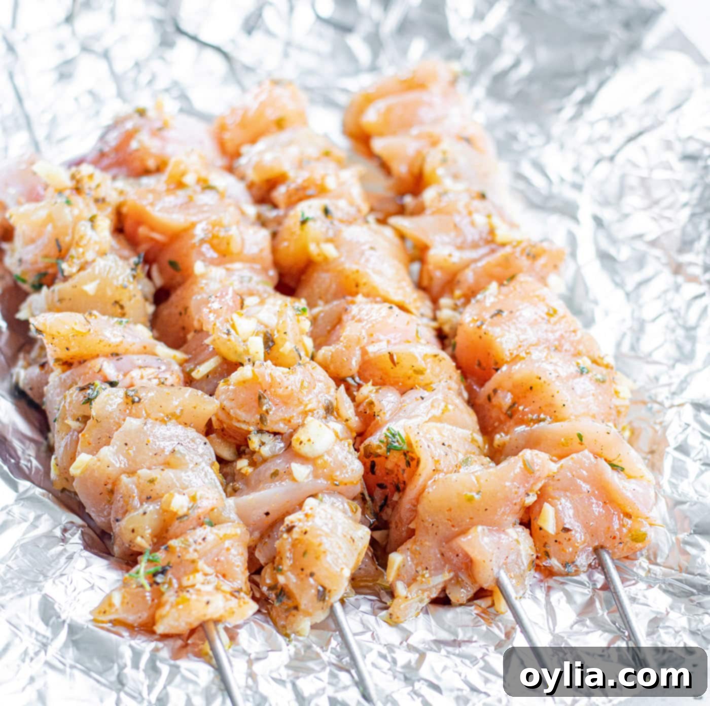 Marinated chicken threaded onto skewers, ready for grilling
