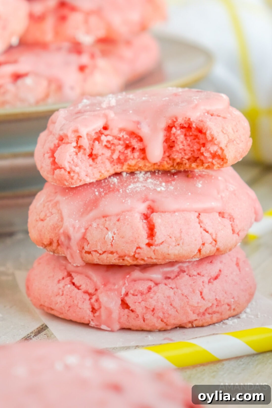 Stack of beautiful pink Strawberry Cake Mix Cookies, glazed and ready to eat.