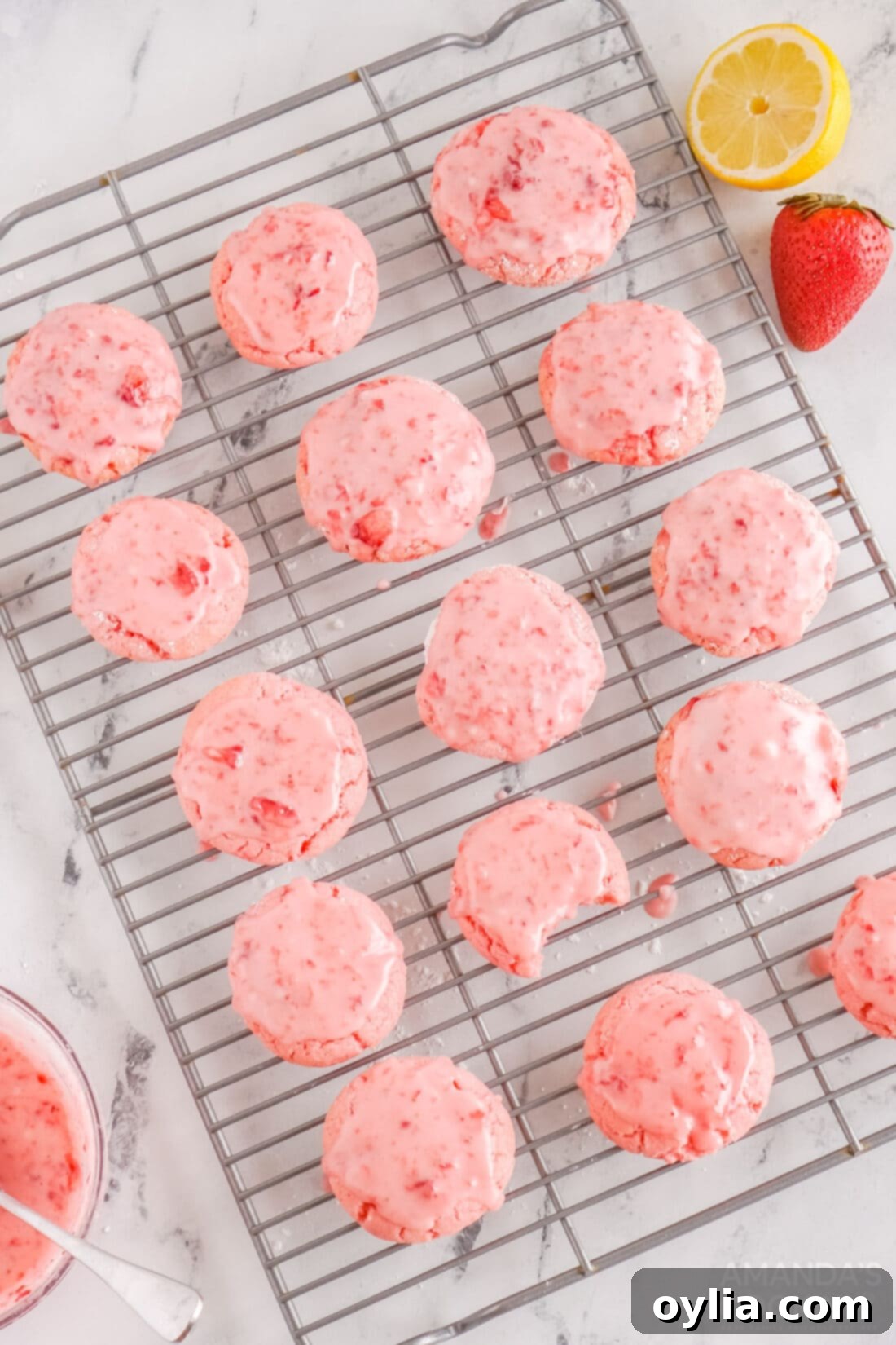 Freshly baked strawberry cookies cooling on a wire rack.