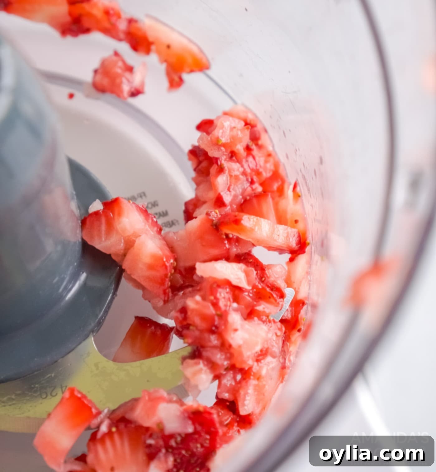 Fresh strawberries and lemon juice blending in a food processor for the glaze.
