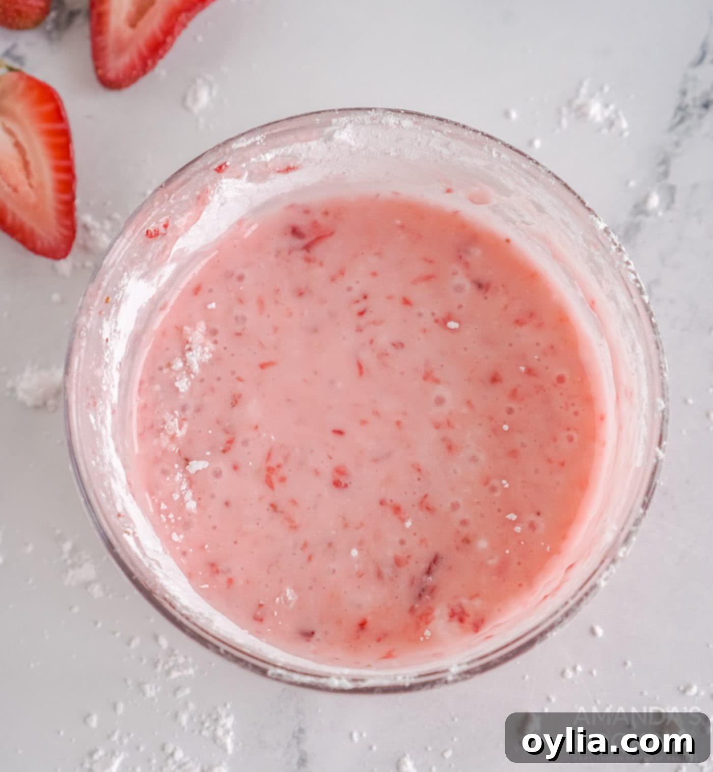 Smooth, vibrant pink strawberry lemon glaze in a bowl.