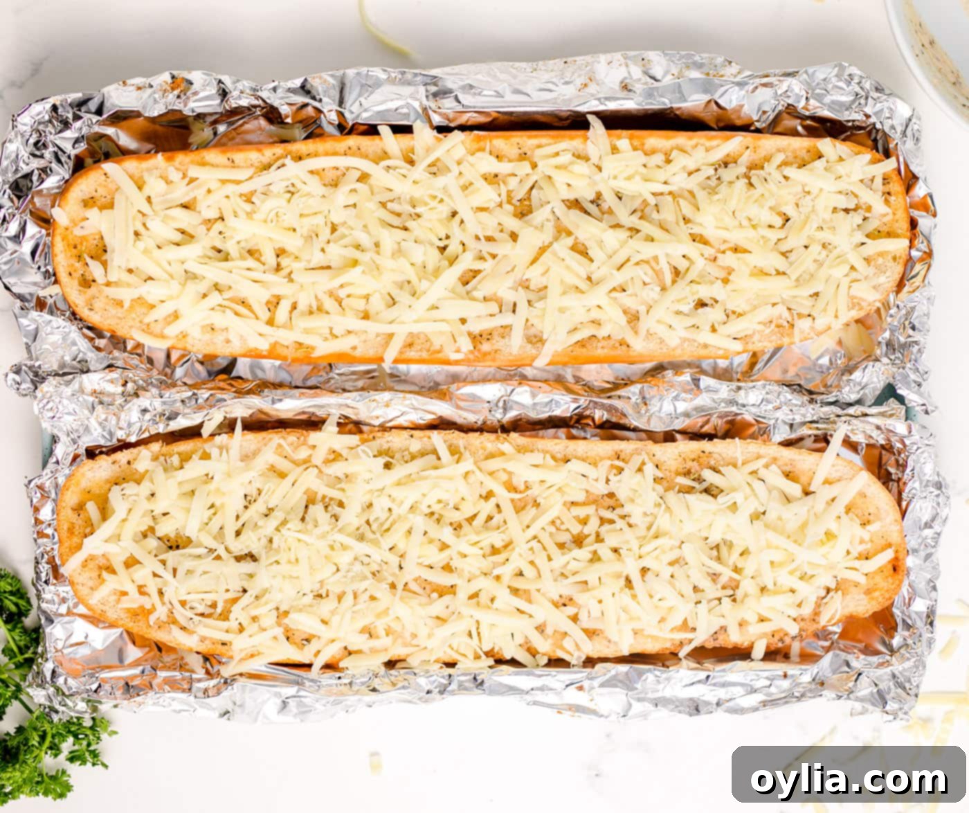 Cheesy garlic bread on a baking pan with melted mozzarella, fresh from the broiler