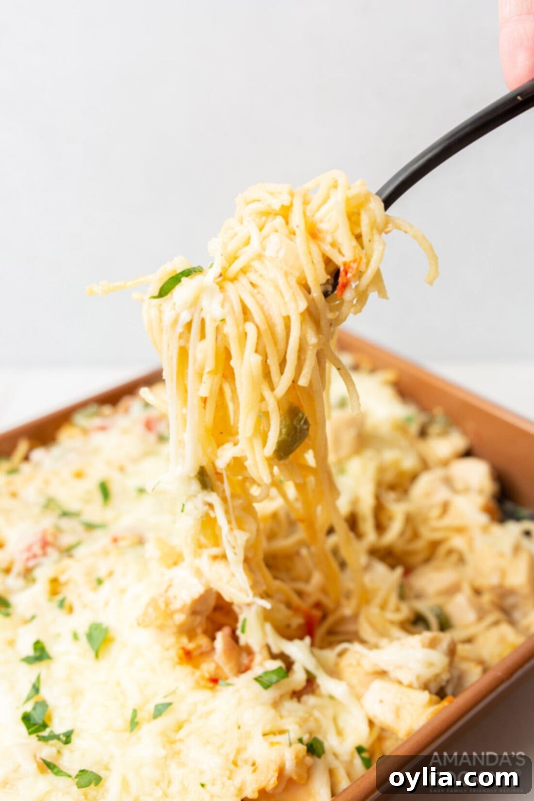 Lifting chicken spaghetti with serving fork