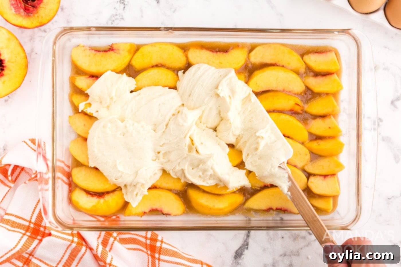 Golden Peach Upside Down Cake 11 spread cake batter on top of peaches in a baking dish