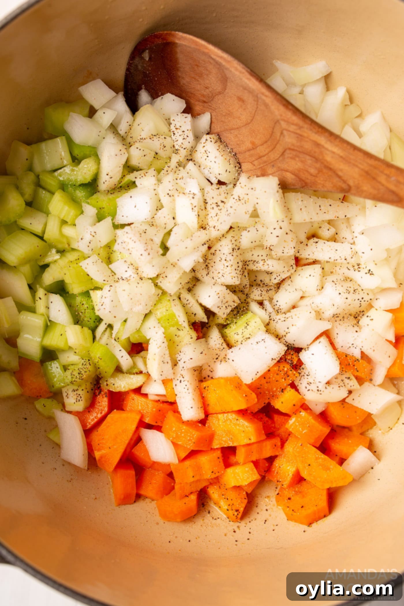 carrots, onion, and celery sweating in butter in a pot for chicken noodle soup