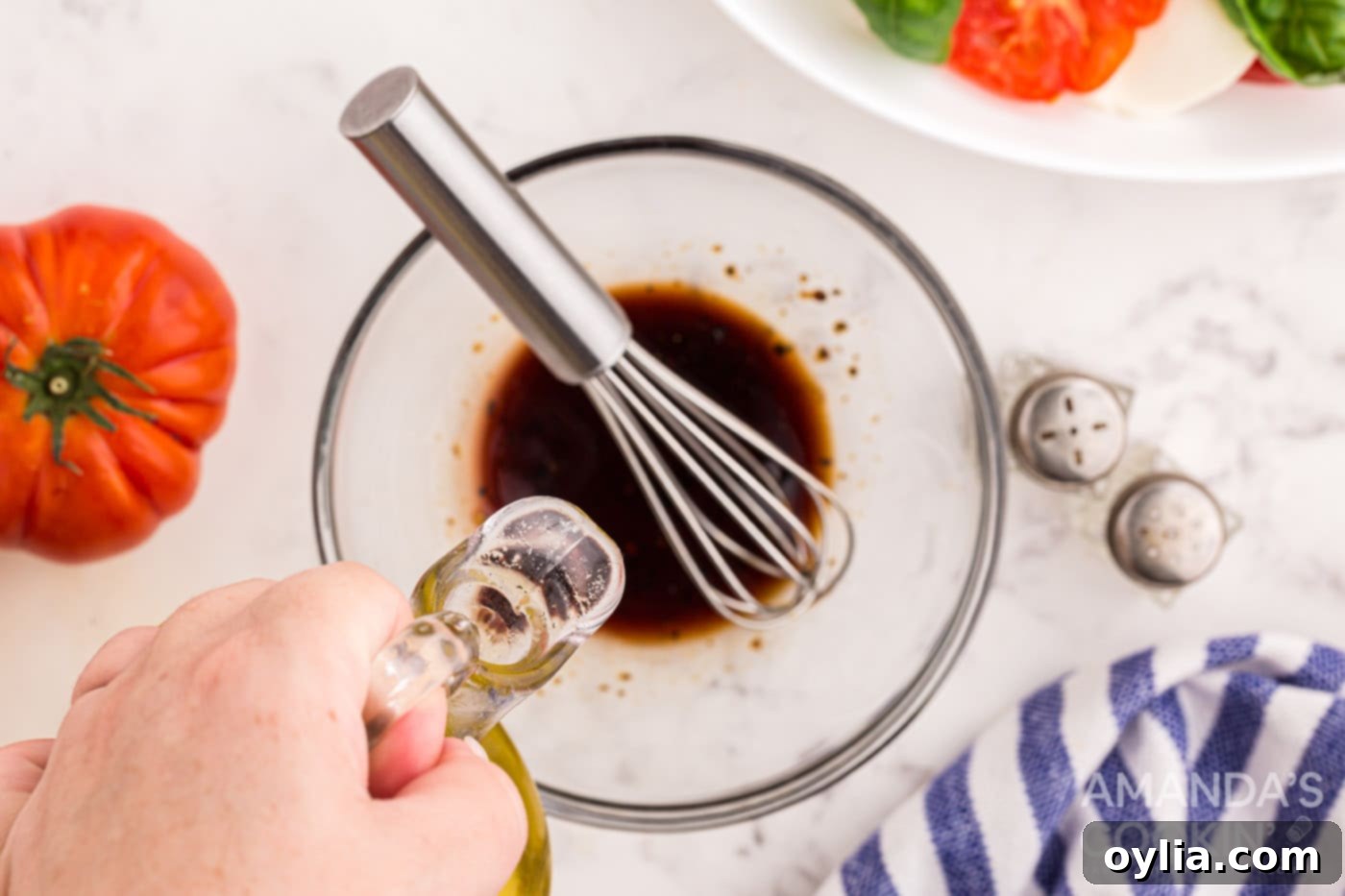 balsamic, pepper, olive oil, and salt in a bowl with whisk