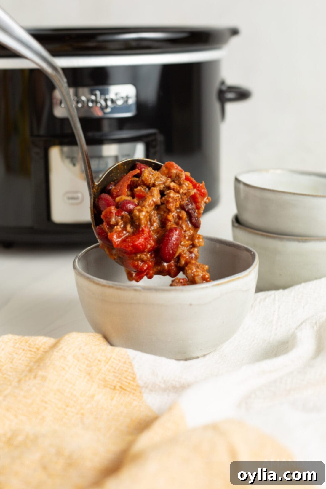 Slow Cooker Comfort Chili 7 A large serving spoon scooping a generous portion of thick, flavorful Crockpot Chili from the slow cooker, ready to be served into individual bowls.