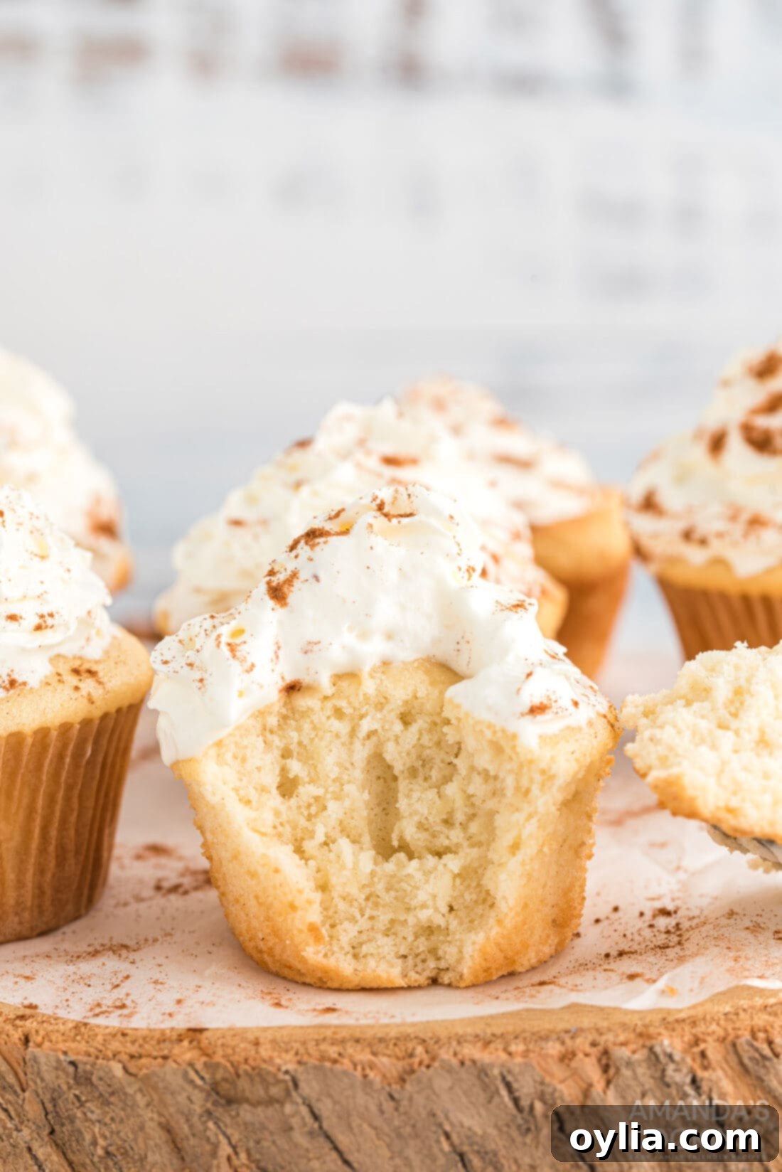 A perfectly baked apple pie cupcake with a bite taken out, revealing its moist and apple-infused interior.