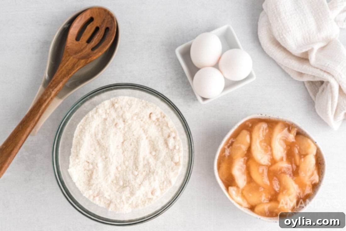 The three simple ingredients laid out: a box of cake mix, a can of apple pie filling, and a bowl of eggs, ready for baking.