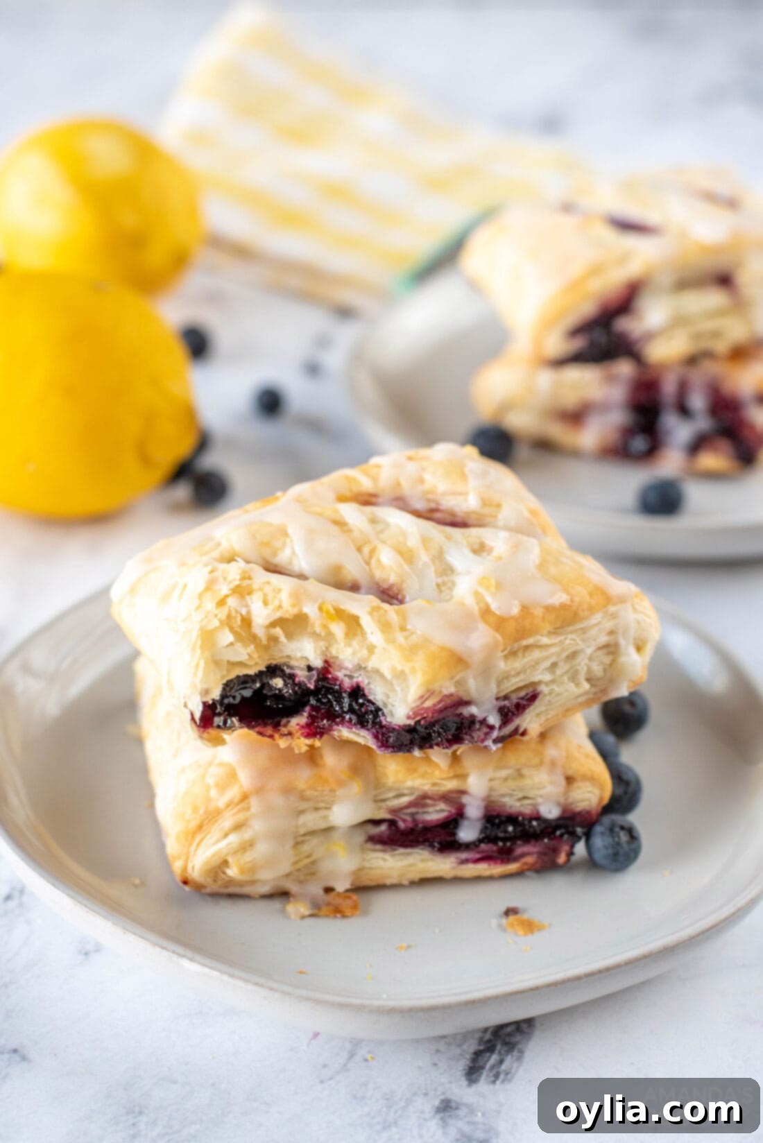 Close-up of a Lemon Blueberry Croissant Hand Pie with a bite taken out, showing the fruit filling