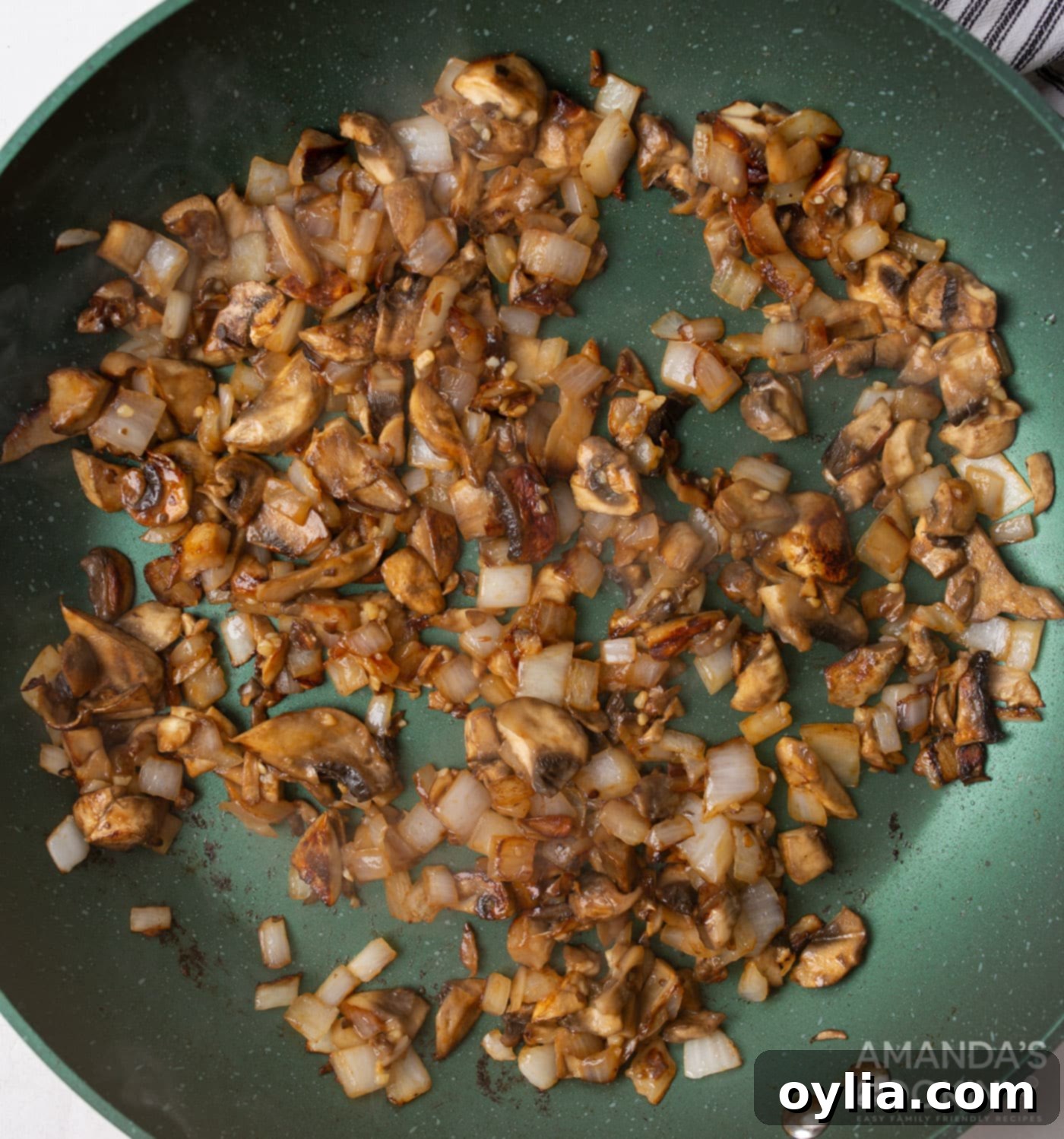 mushrooms and onion in a skillet with garlic
