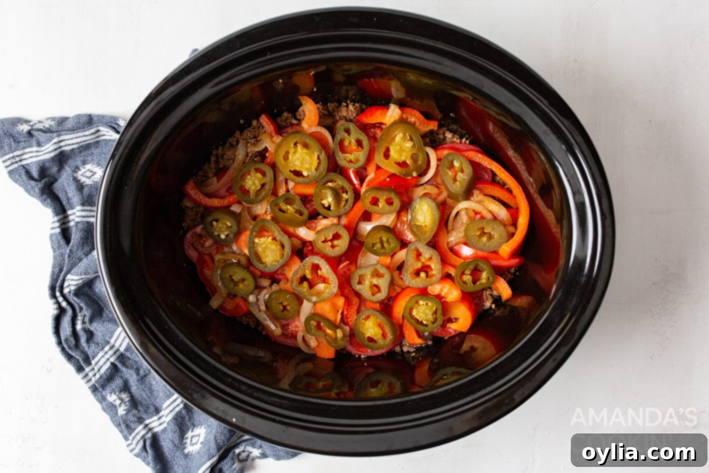 jalepenos on top of tomatoes and beef in crockpot