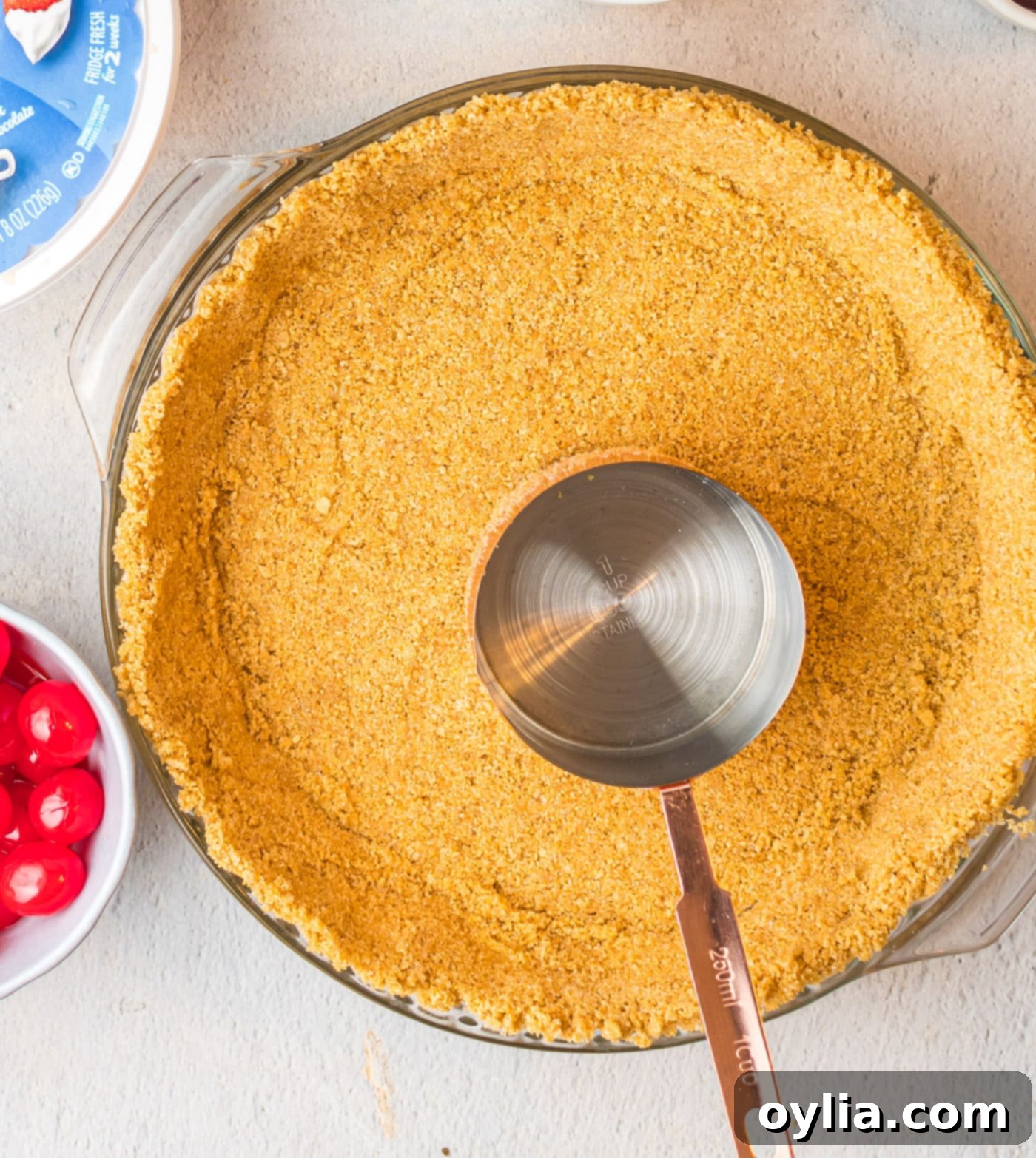 graham cracker crust with measuring cup in a pie pan