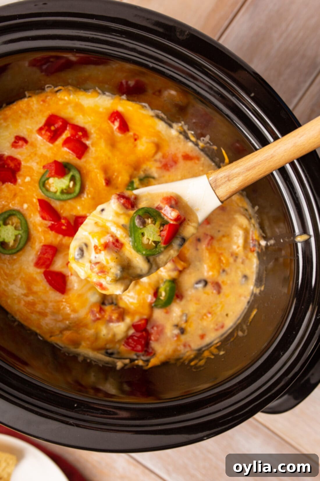 serving spoon of crockpot mexican chicken with melted cheese and fresh cilantro