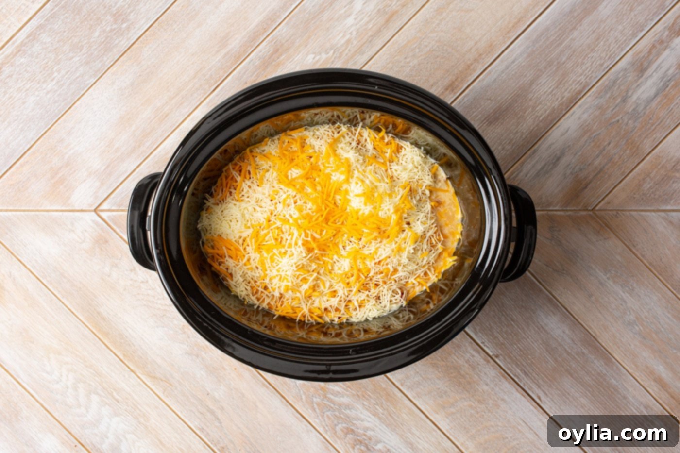 melted cheese on top of crockpot Mexican chicken, ready to serve