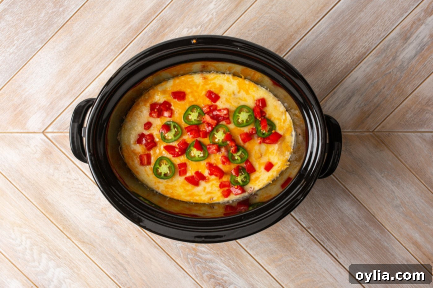 crockpot Mexican chicken garnished with diced tomatoes, jalapeños, and fresh cilantro