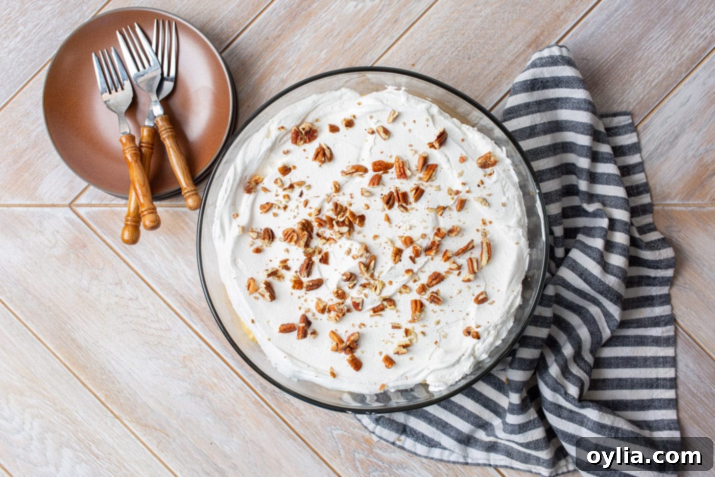 Crushed pecans are sprinkled on top of the whipped cream layer, completing the pumpkin trifle.