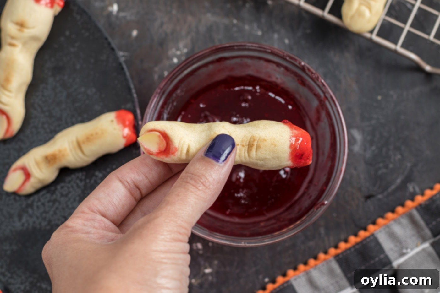 dipping witch finger cookies in jam