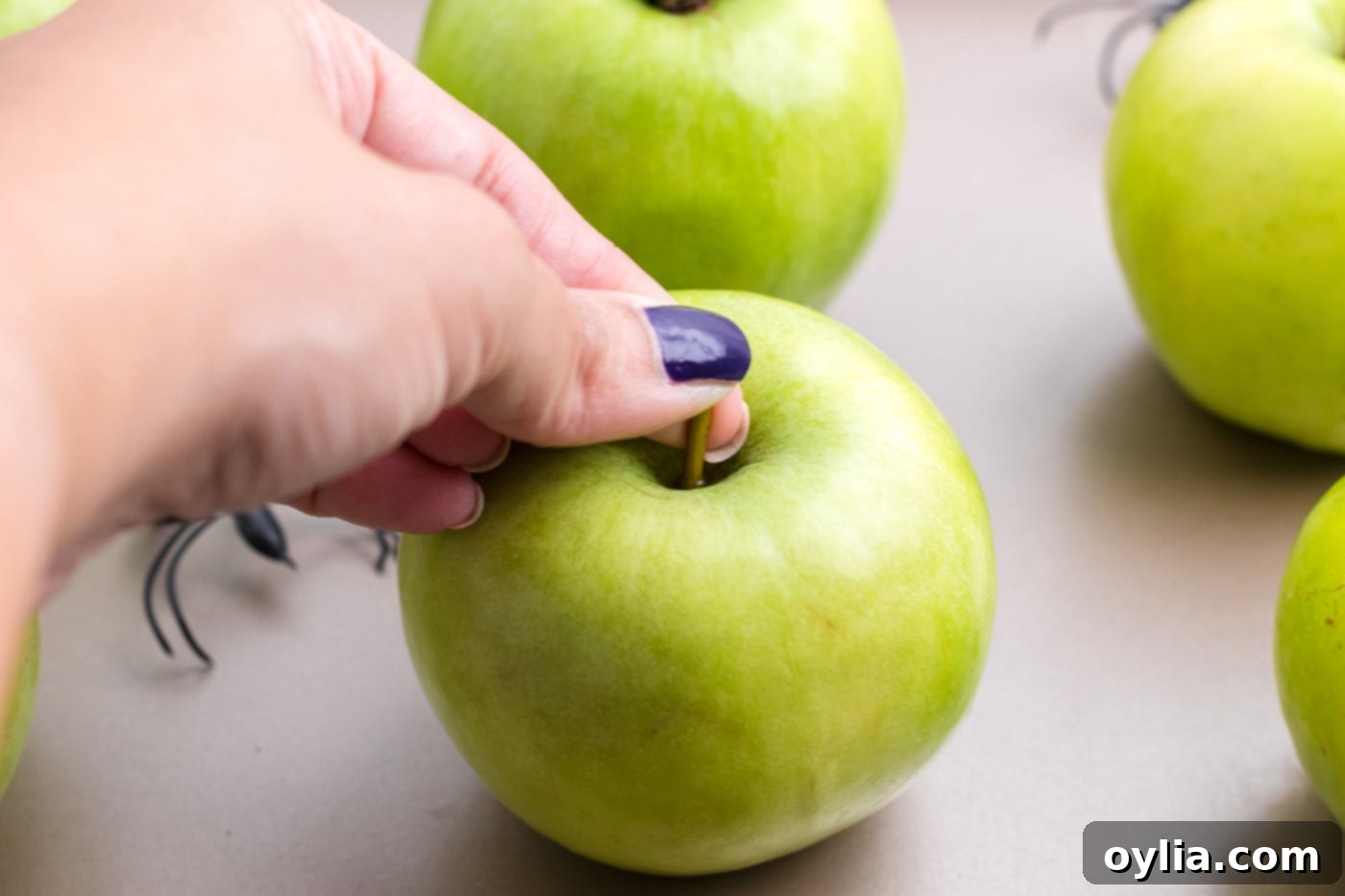 hand removing stem of green apple