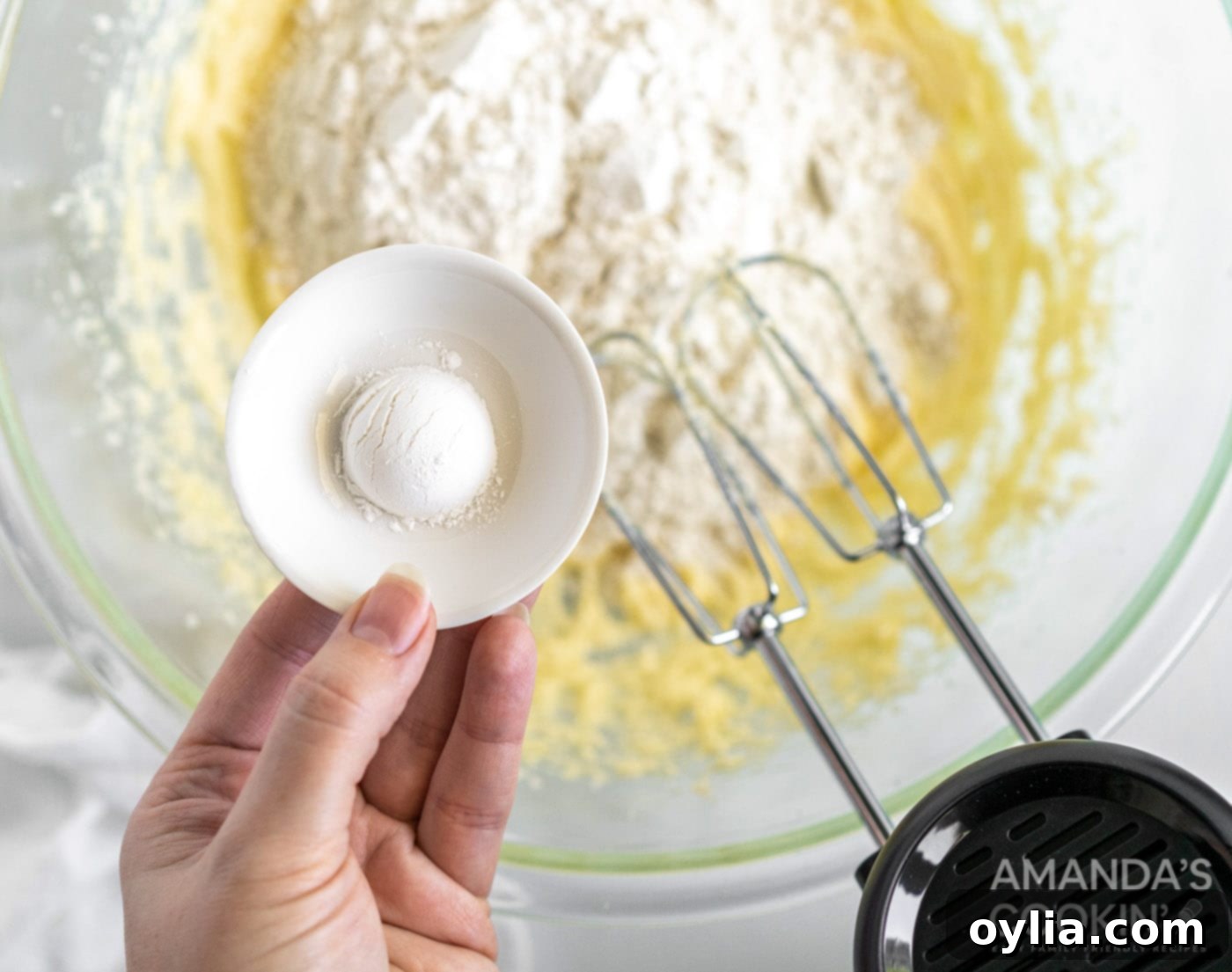 baking powder in a bowl over pound cake mix